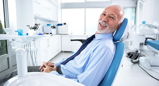 Man smiling while sitting in dentist's treatment chair