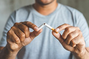 Closeup of man breaking cigarette