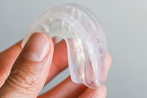 Closeup of patient holding clear mouthguard