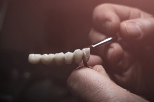 Lab technician painting replacement teeth