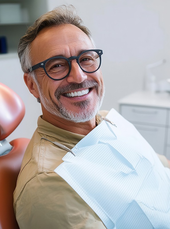 Happy middle-aged dental patient in treatment chair